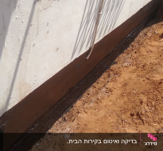 קיר עם איטום חום ליד אדמה חשופה
